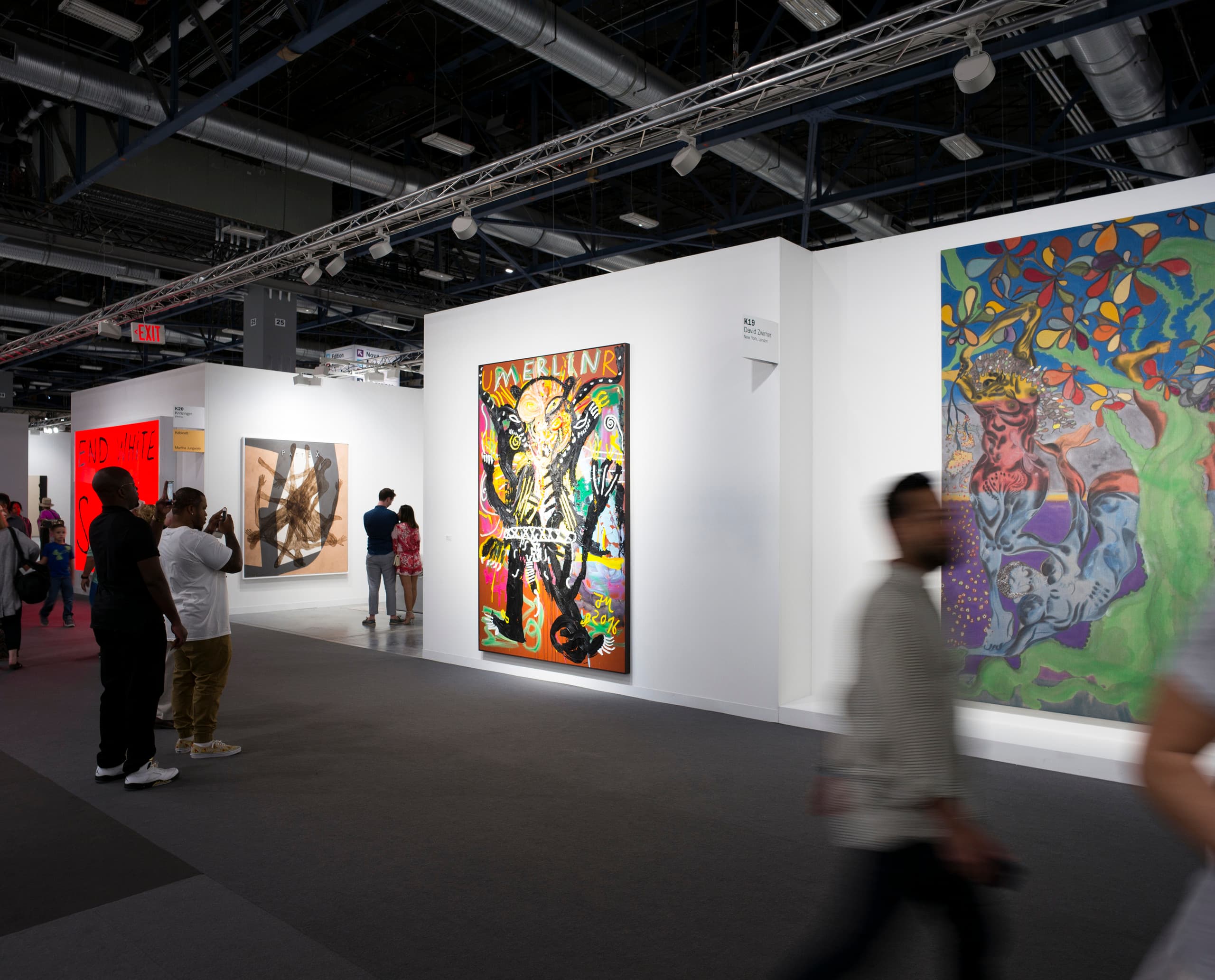 Kunstausstellung mit ERCO Beleuchtung: Besucher betrachten Gemälde auf der Art Basel in Miami.