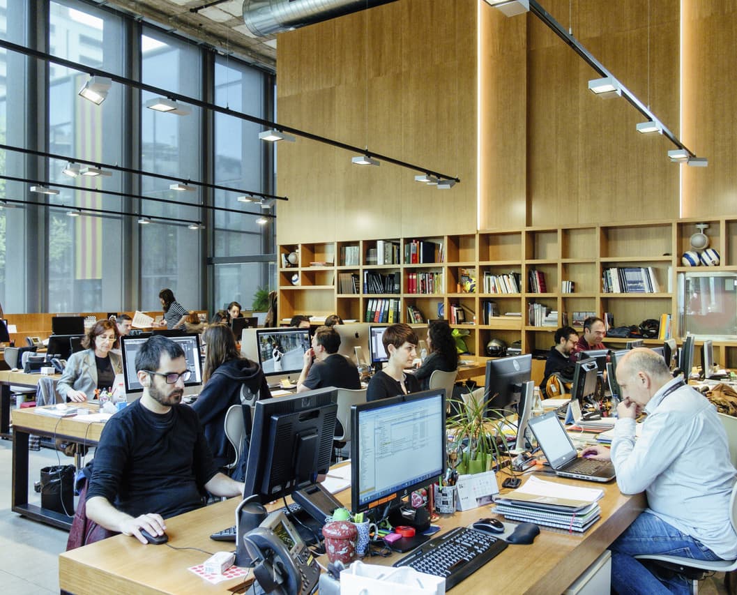 ERCO Bürobeleuchtung mit flexiblen Stromschienenstrahlern für ergonomisches Licht am Arbeitsplatz.