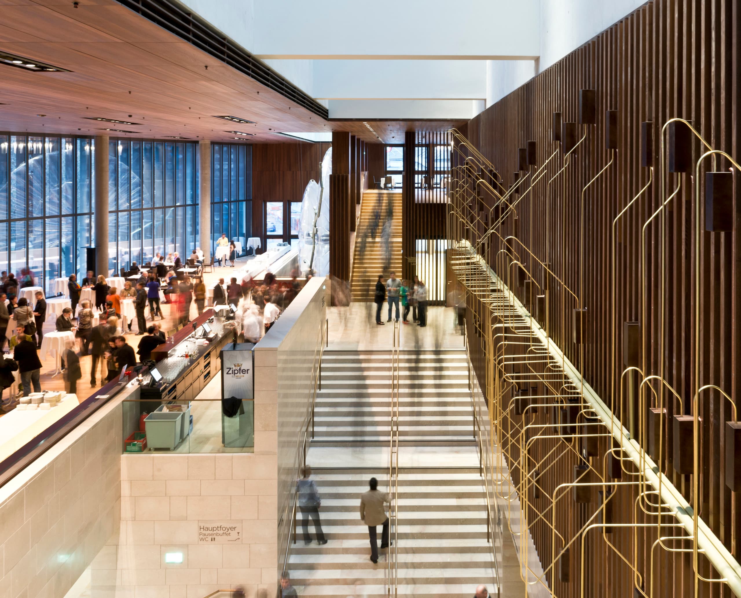 Das Foyer des Musiktheaters Linz mit Treppenhaus und warmem Lichtdesign.