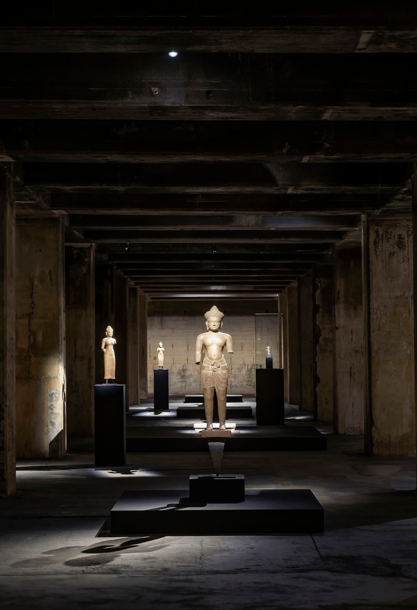 Khmer-Skulpturen in der Feuerle Collection, beleuchtet von ERCO Licht, schaffen eine meditative Atmosphäre in Berlin.