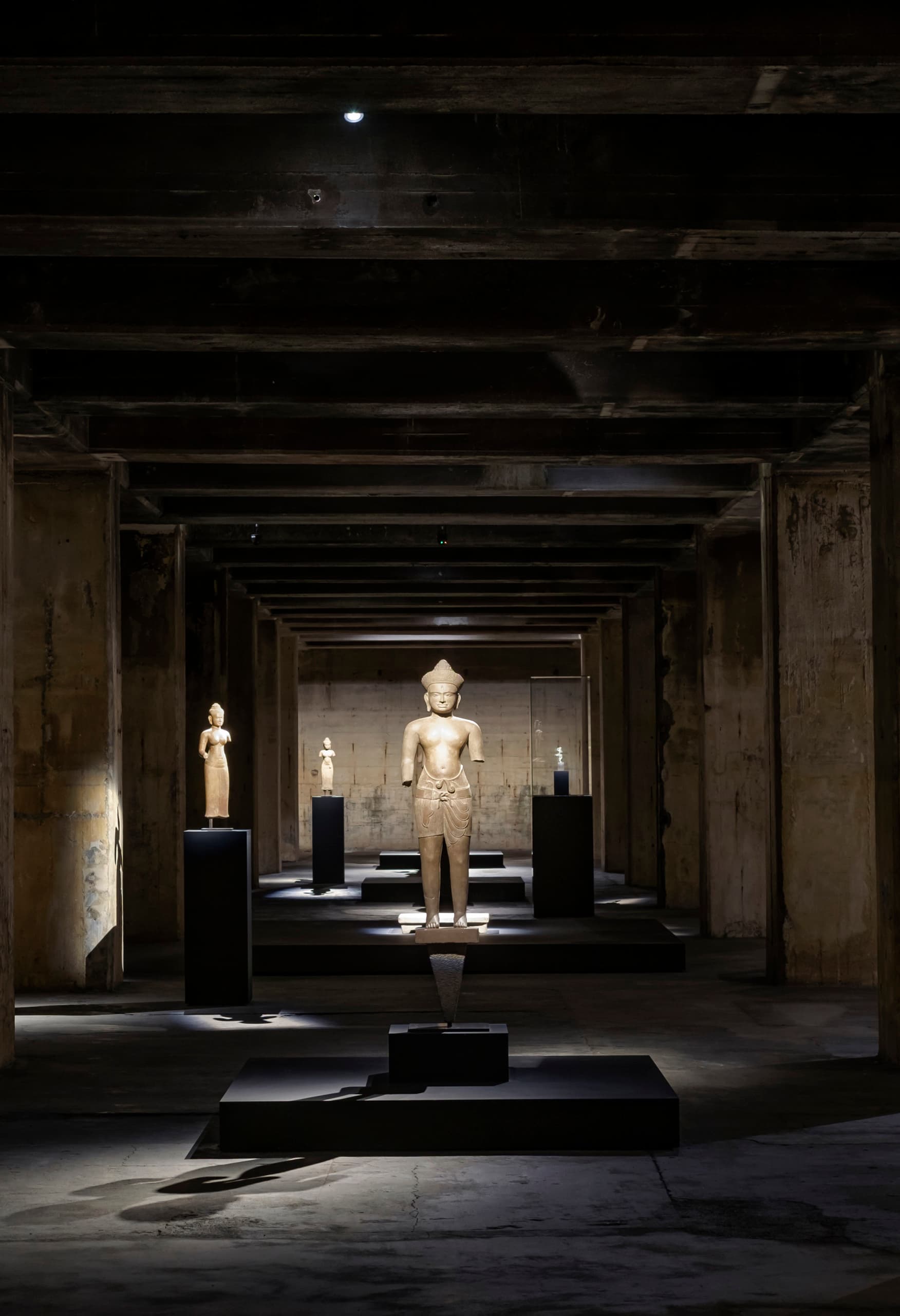 Khmer-Skulpturen in der Feuerle Collection, beleuchtet von ERCO Licht, schaffen eine meditative Atmosphäre in Berlin.