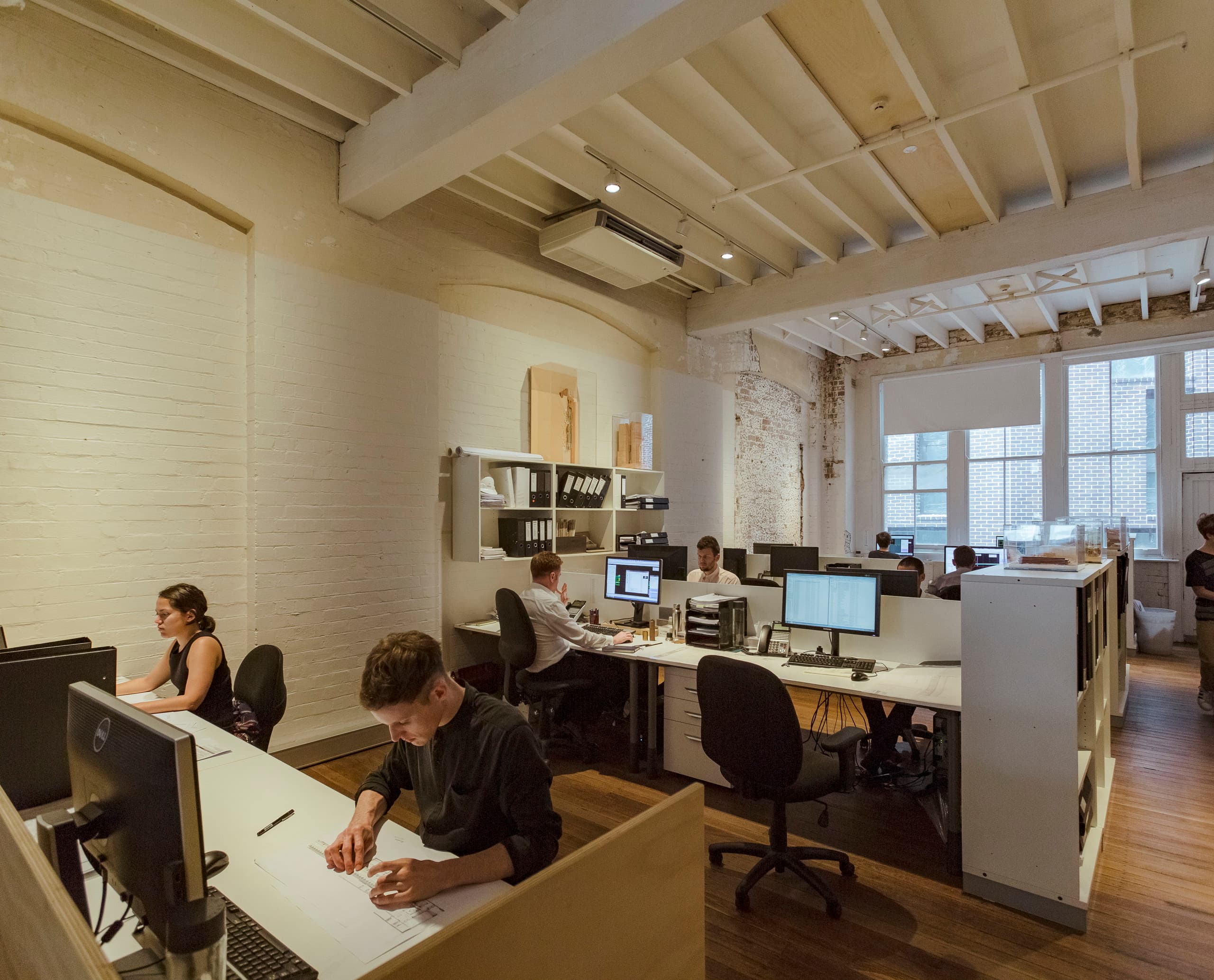 Flexibles ERCO Lichtdesign mit Downlights an Stromschienen in einem modernen Büro für ergonomisches Licht.