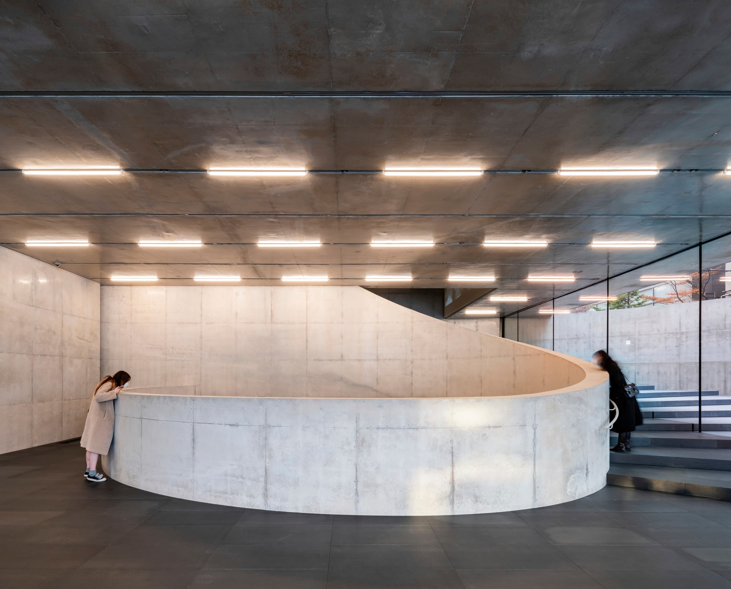 Innenansicht der SongEun Art & Cultural Foundation mit Betonwendeltreppe und ERCO Beleuchtung.